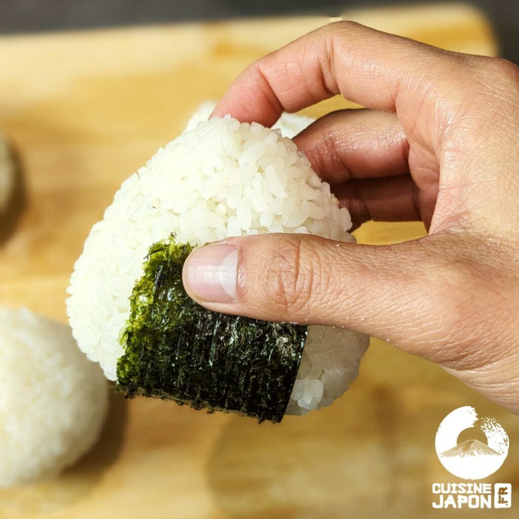 Laissez le nori coller en dessous et derrière l'onigiri