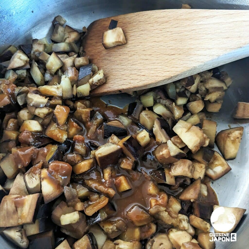 Dans une poêle huilée, faire sauter l'aubergine et les shiitakés sur feu moyen. Lorsque l'aubergine est tendre, ajouter l'assaisonnement et faire sauter 5 minutes à feu moyen, jusqu'à que le liquide soit évaporé.